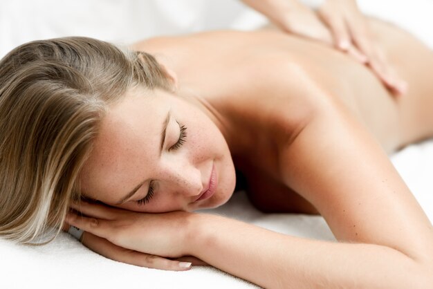 Young blonde woman having massage in the spa salon