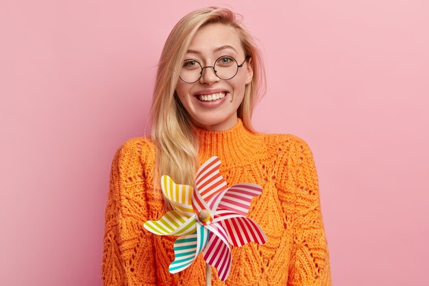 Молодая блондинка в оранжевом свитере