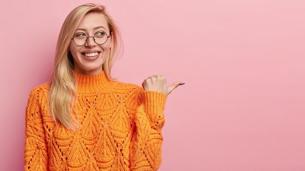 주황색 스웨터에 젊은 금발 여자