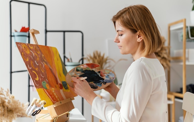 Young blonde woman painting with acrylics