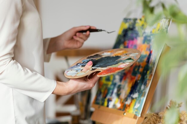 Young blonde woman painting with acrylics