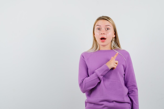 Young blonde woman in a purple sweater