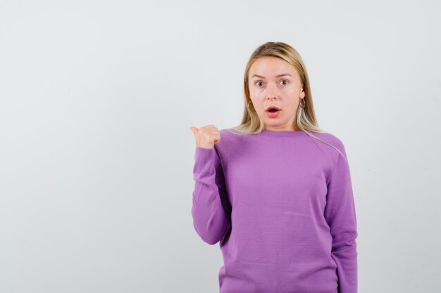 Young blonde woman in a purple sweater