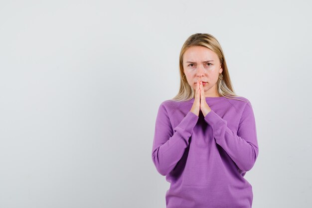 Foto gratuita giovane donna bionda con un maglione viola