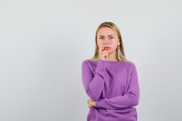 Young blonde woman in a purple sweater