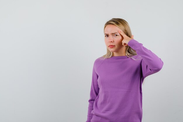 Young blonde woman in a purple sweater