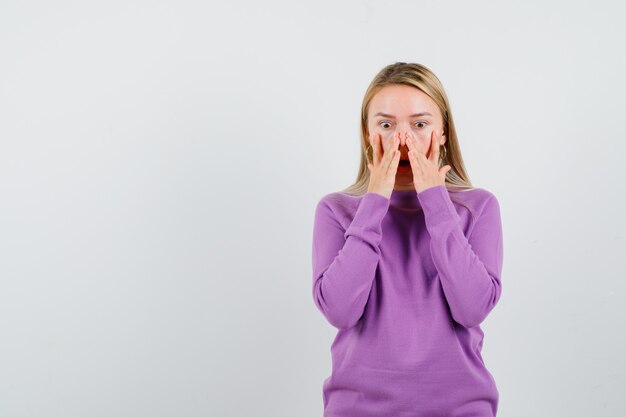 Young blonde woman in a purple sweater