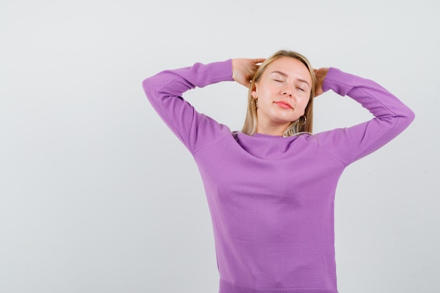 Young blonde woman in a purple sweater