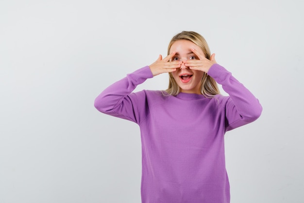 Young blonde woman in a purple sweater