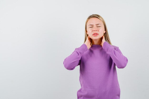 Young blonde woman in a purple sweater