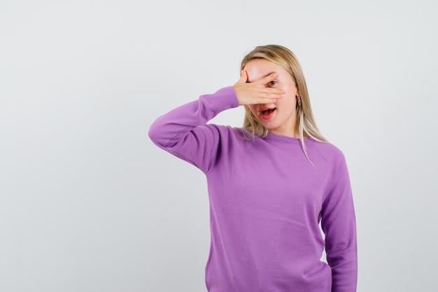 Foto gratuita giovane donna bionda con un maglione viola