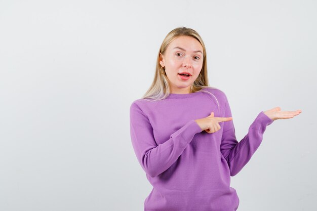 Young blonde woman in a purple sweater