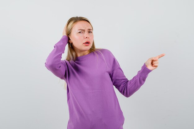 Young blonde woman in a purple sweater