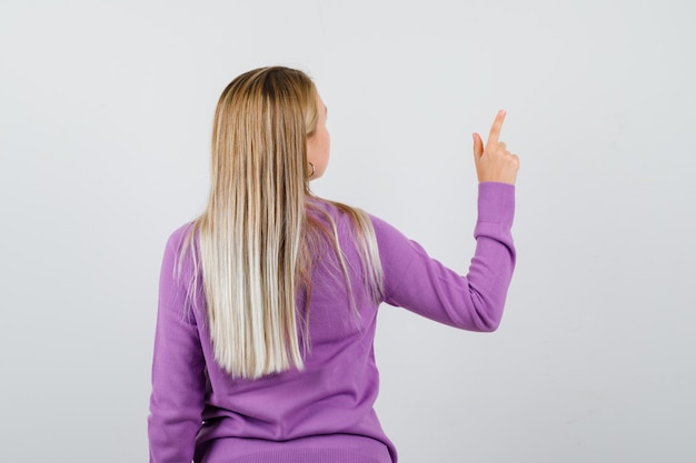 Young blonde woman in a purple sweater