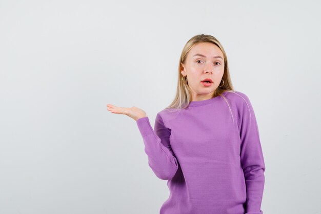 Young blonde woman in a purple sweater