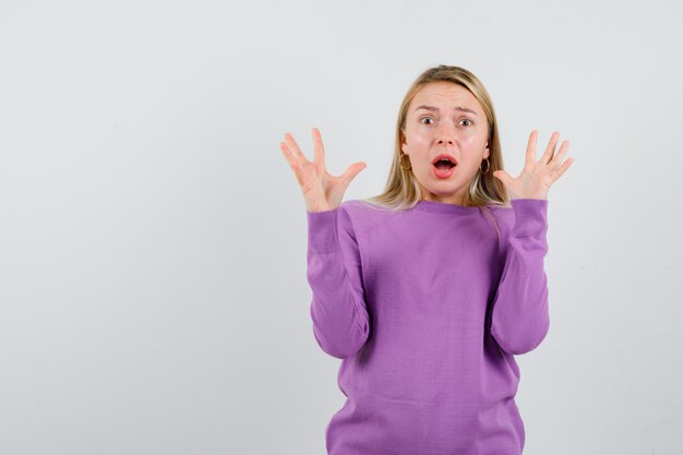 Young blonde woman in a purple sweater