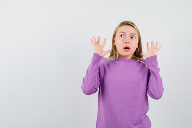 Young blonde woman in a purple sweater