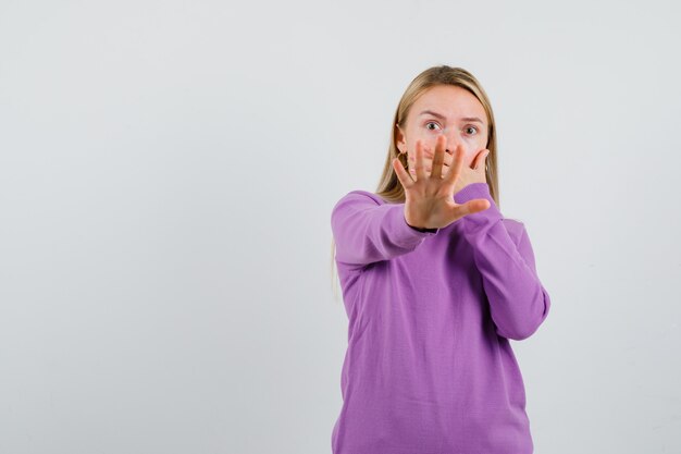 Young blonde woman in a purple sweater