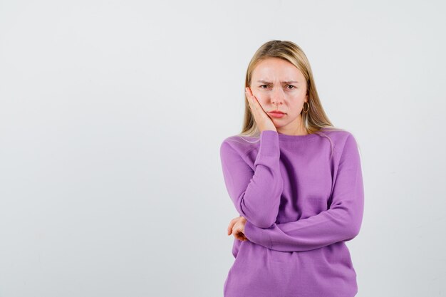 Young blonde woman in a purple sweater