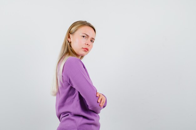 Young blonde woman in a purple sweater