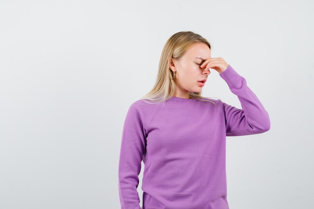 Young blonde woman in a purple sweater