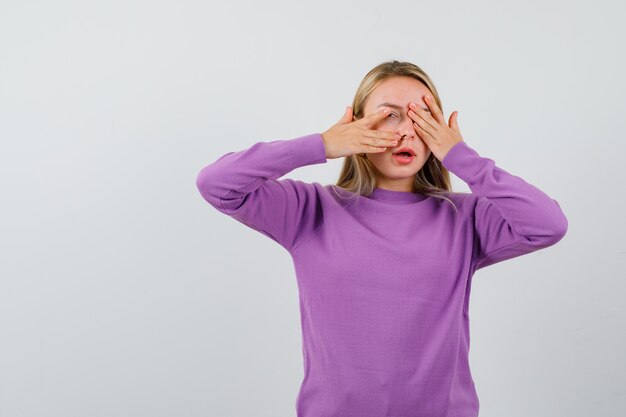 Young blonde woman in a purple sweater