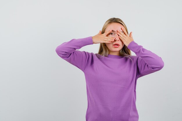 Young blonde woman in a purple sweater