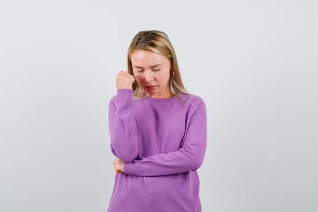 Young blonde woman in a purple sweater