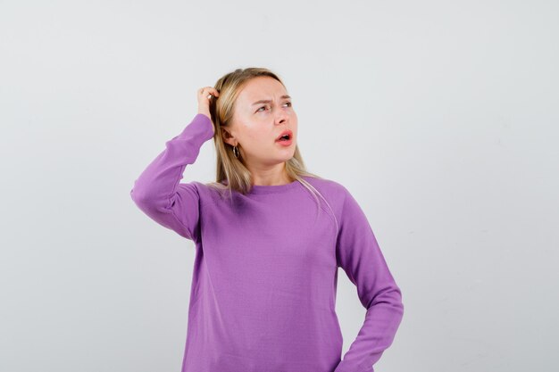 Young blonde woman in a purple sweater