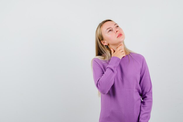 Young blonde woman in a purple sweater