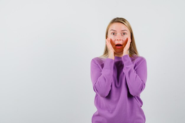 Young blonde woman in a purple sweater