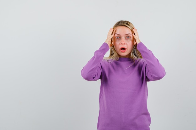 Young blonde woman in a purple sweater