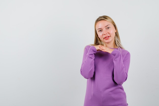 Young blonde woman in a purple sweater