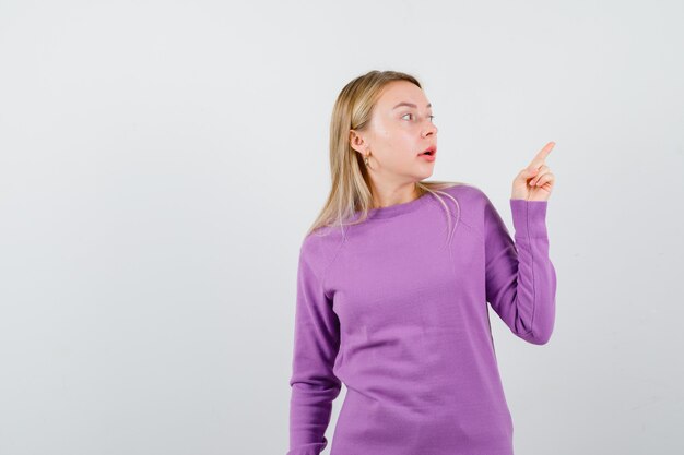 Young blonde woman in a purple sweater