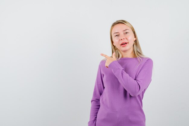 紫色のセーターを着た若いブロンドの女性