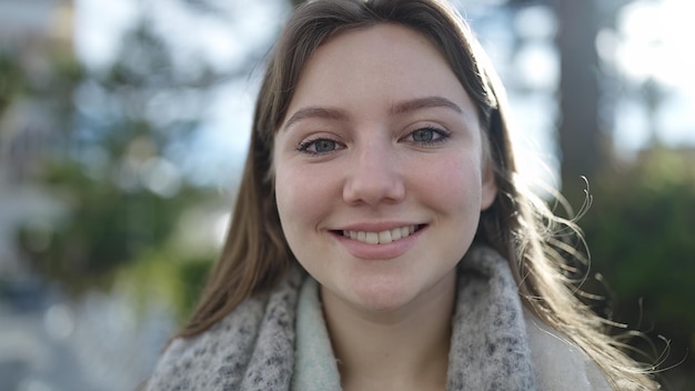 Young blonde woman smiling confident standing at park