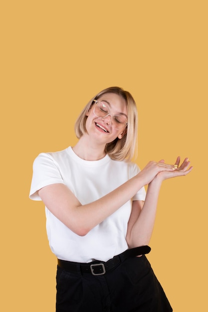 Young blonde woman smiling isolated on yellow
