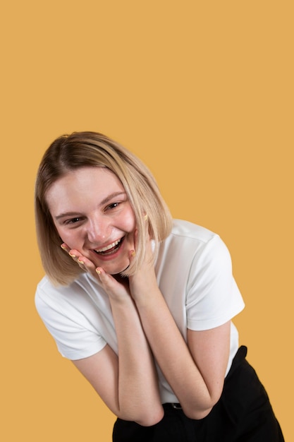 Young blonde woman smiling isolated on yellow