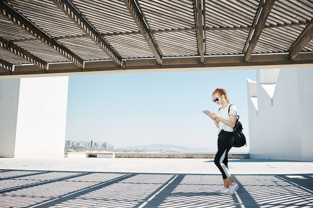 Young blonde woman in sportswear listening music