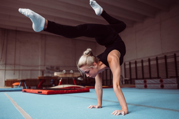 Foto gratuita giovane donna bionda di formazione per il campionato di ginnastica