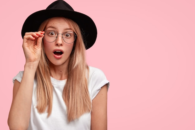 Young blonde woman wearing big hat