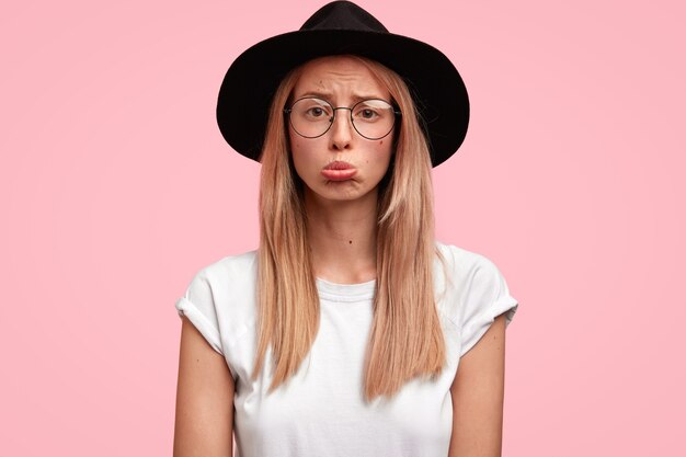 Young blonde woman wearing big hat