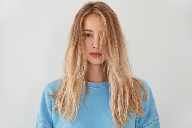 Free photo young blonde woman wearing blue sweater