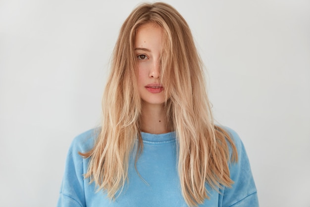 Young blonde woman wearing blue sweater
