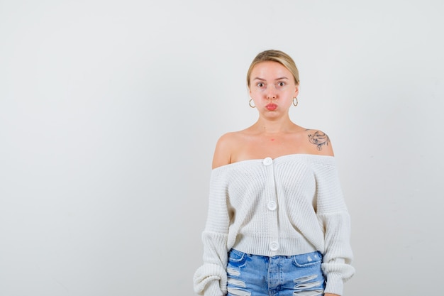 Free photo young blonde woman in a white cardigan