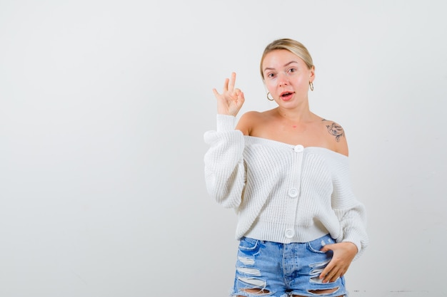 Giovane donna bionda in un cardigan bianco