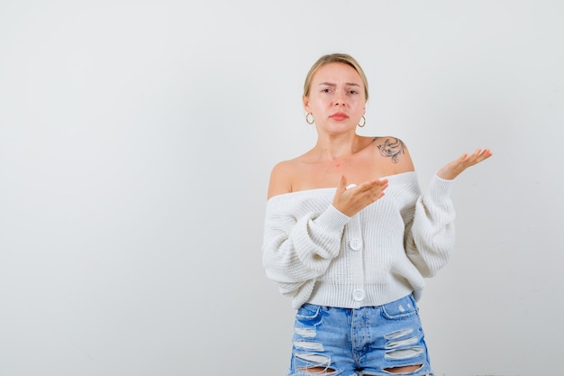 Free photo young blonde woman in a white cardigan