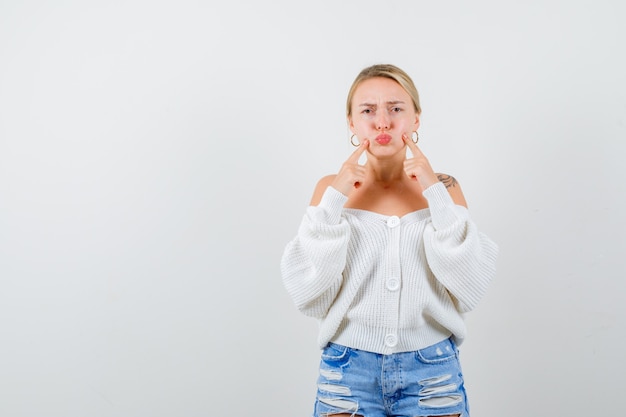 Young blonde woman in a white cardigan