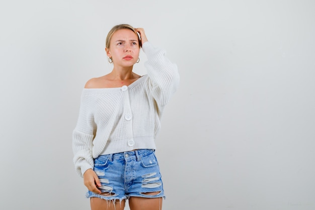 Young blonde woman in a white cardigan