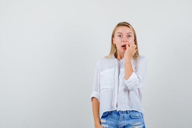 Giovane donna bionda in camicia bianca